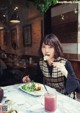 A woman sitting at a table with a plate of food.