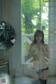 A naked woman standing in front of a glass door.